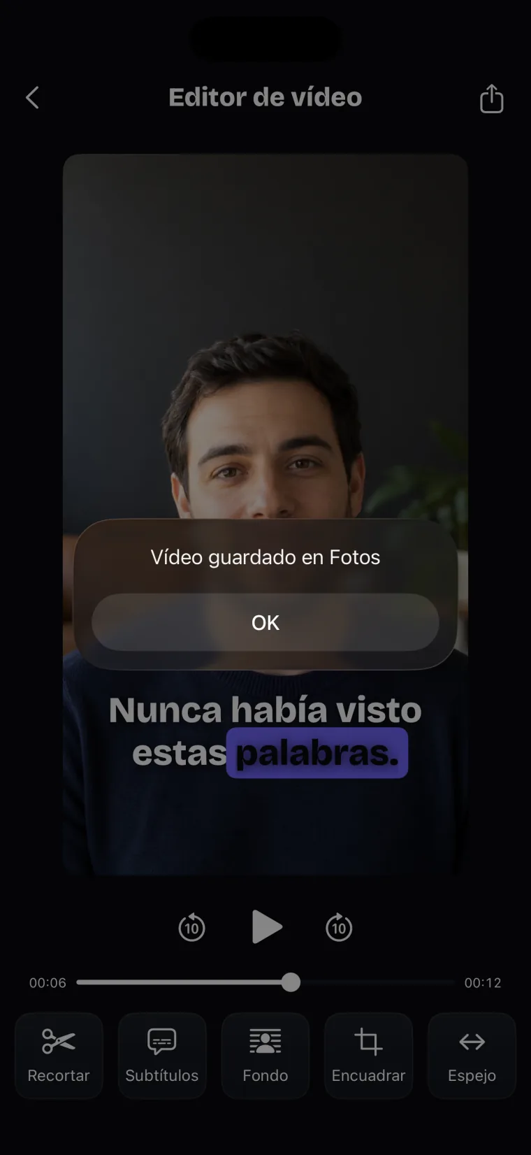 El Editor de vídeo con el aviso Vídeo guardado en Fotos sobre la toma, que tiene un subtítulo, y la fila de herramientas abajo.